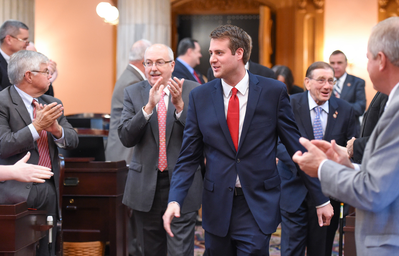 Derek Merrin receives applause from House members as he enters the chamber to be sworn in.