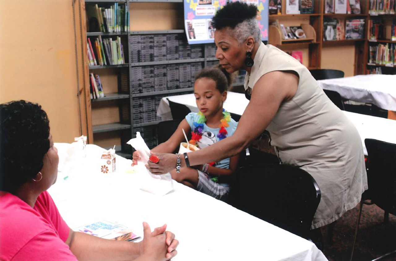 Rep. Ingram helping a child at the Public Library of Cincinnati & Hamlton County's annual summer lunch program