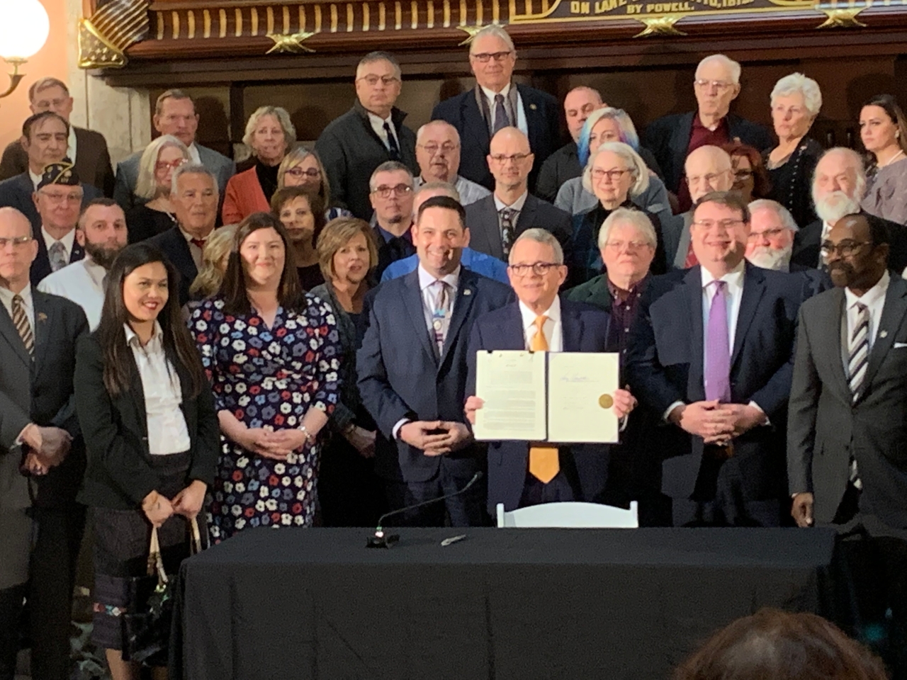 Lawmakers pose for a photo with Gov. DeWine for a bill signing