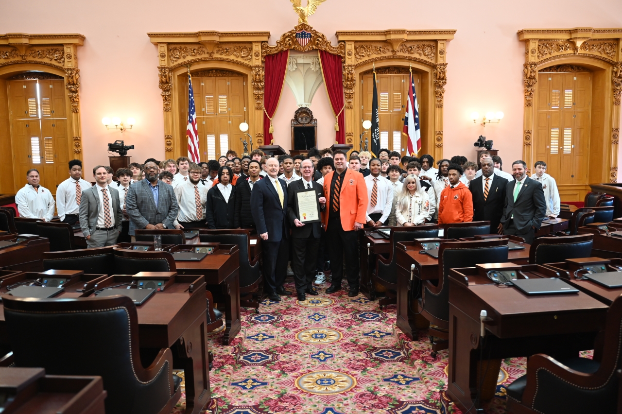 Rep. Oelslager presents the Massillon Tigers State Champion Football Team a commendation alongside his colleagues.