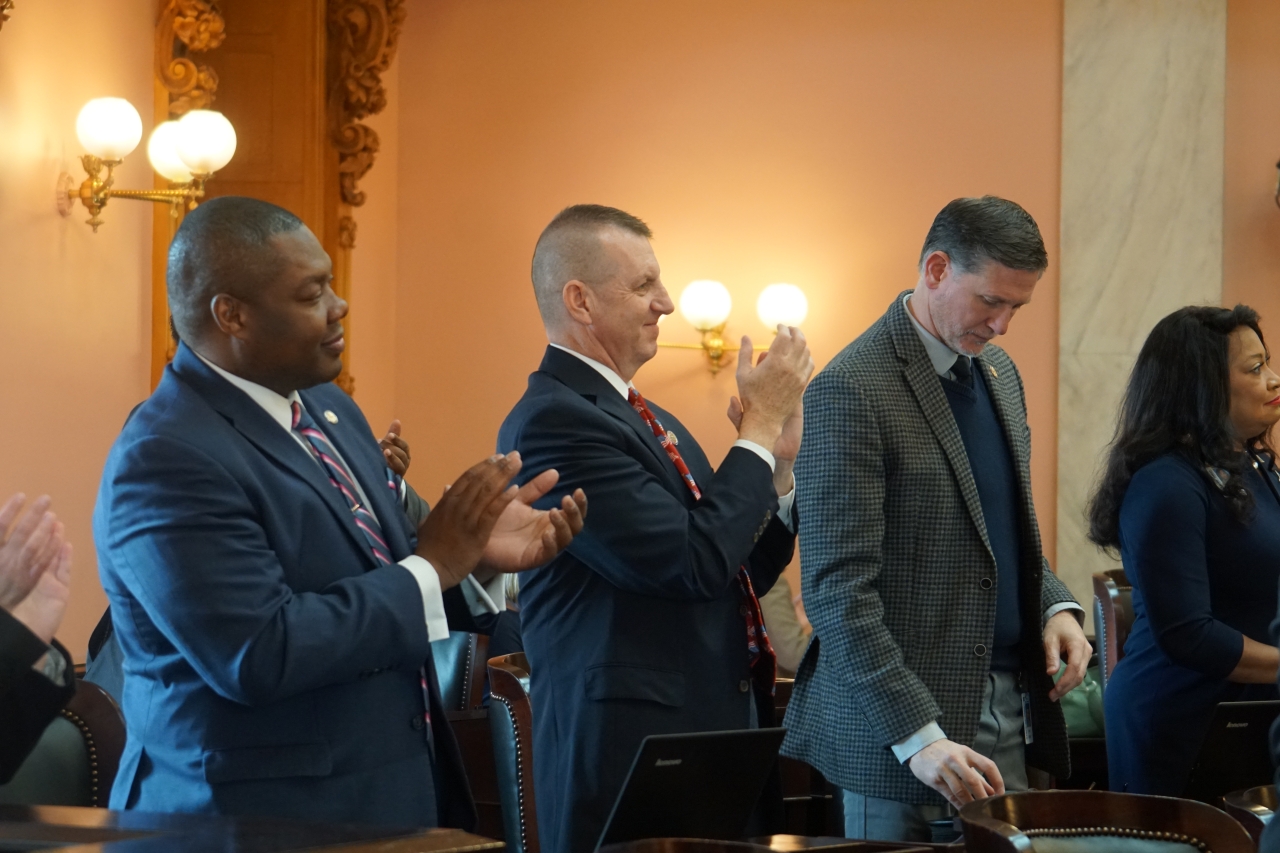 Rep. Rogers applauds during session