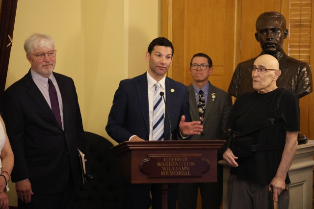 Photo of Rep. Synenberg speaking at a podium during the press conference